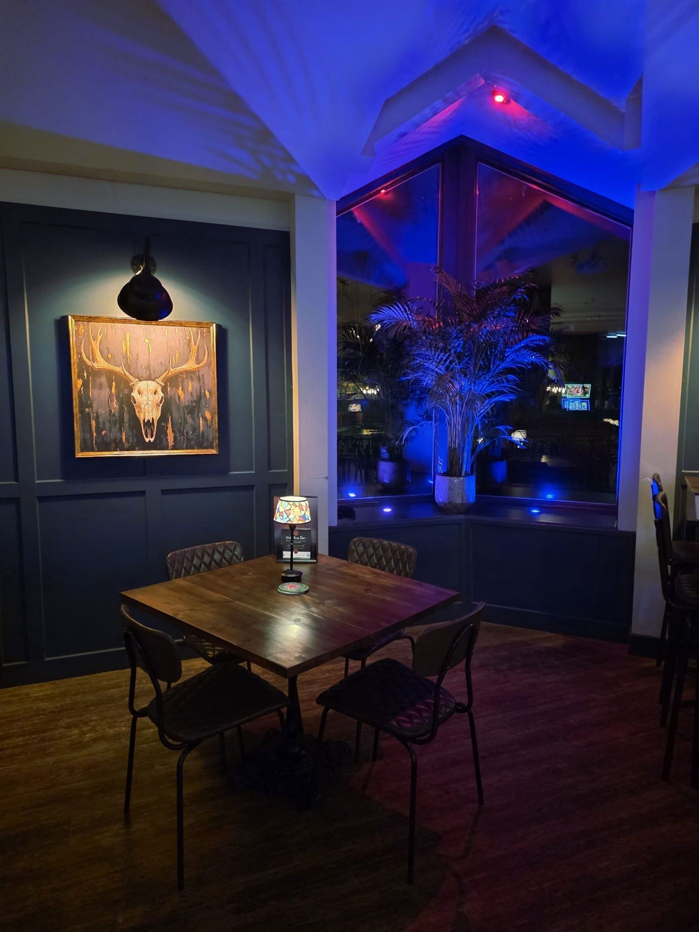 A corner table beneath framed artwork