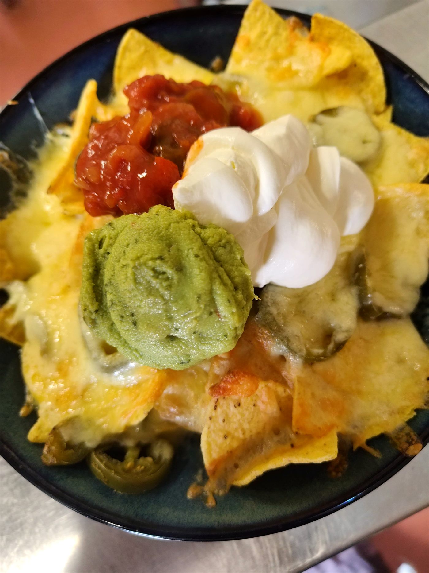 Loaded cheese nachos with salsa, guacamole and sour cream