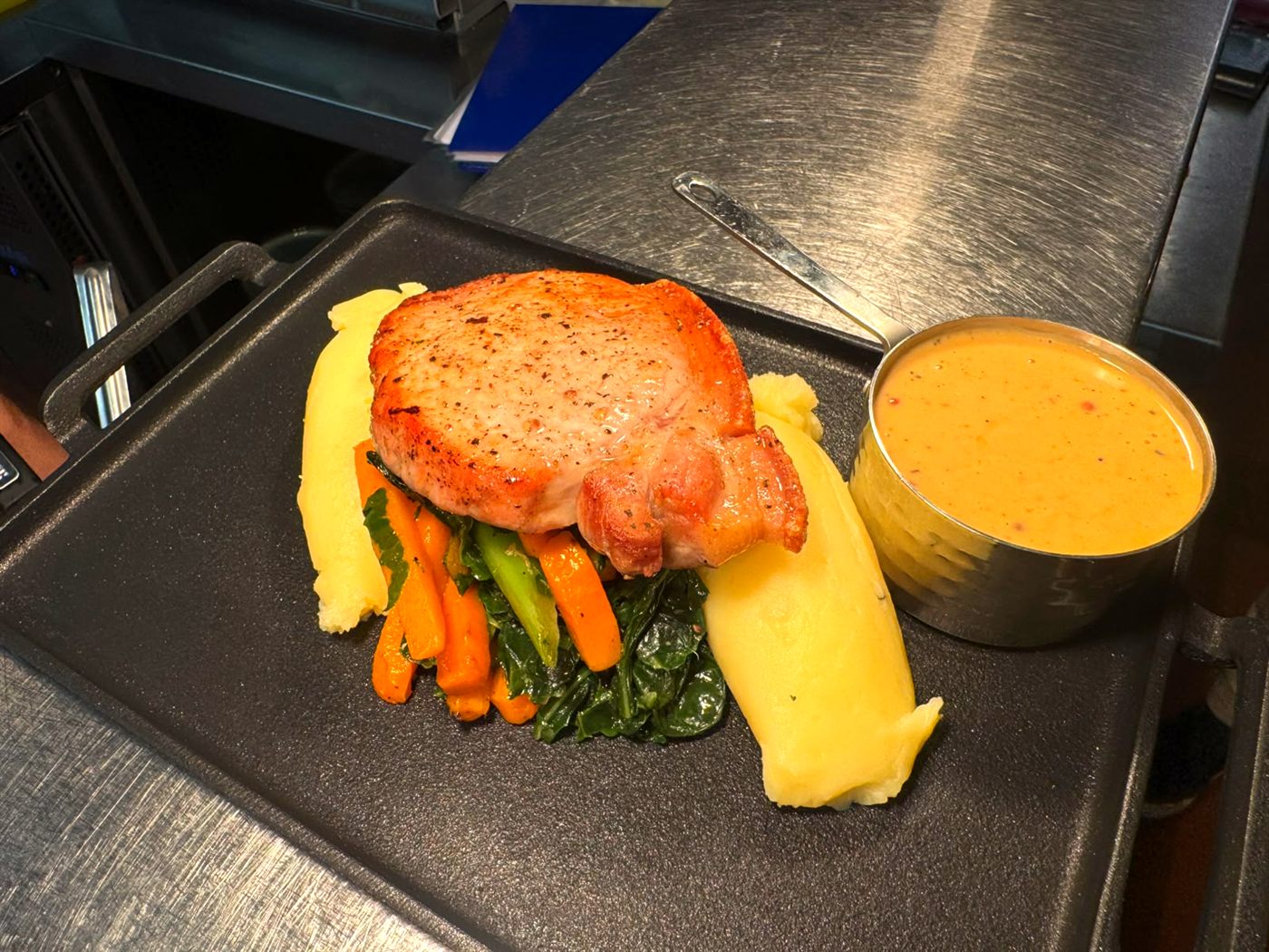 Pan-fried pork loin with creamy mash, seasonal veg and peppercorn sauce